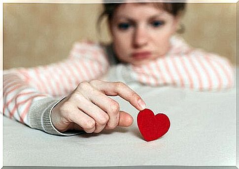 Sad woman touching a heart