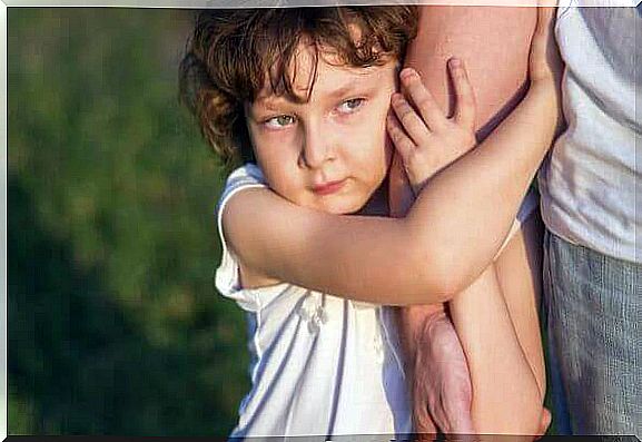 Little girl clinging to her father's arm