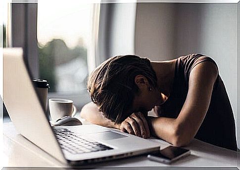 Woman with stress resting her head on the computer