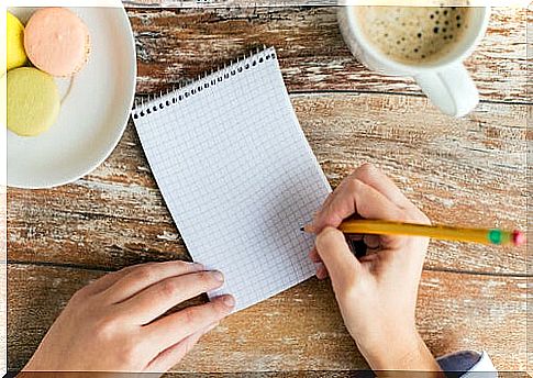 Woman writing goals in a notebook on how to manage time