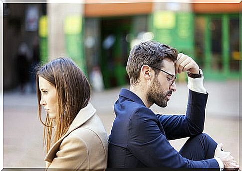 Couple turning their backs to represent saying sorry does not erase the pain caused.