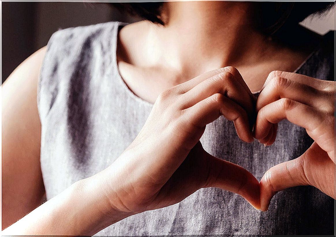 Woman making a heart with her hands as a sign of self-honesty