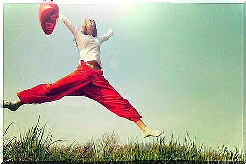 Woman jumping with a red balloon 