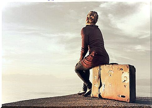 Woman sitting on a suitcase symbolizing the fact that traveling improves your brain health