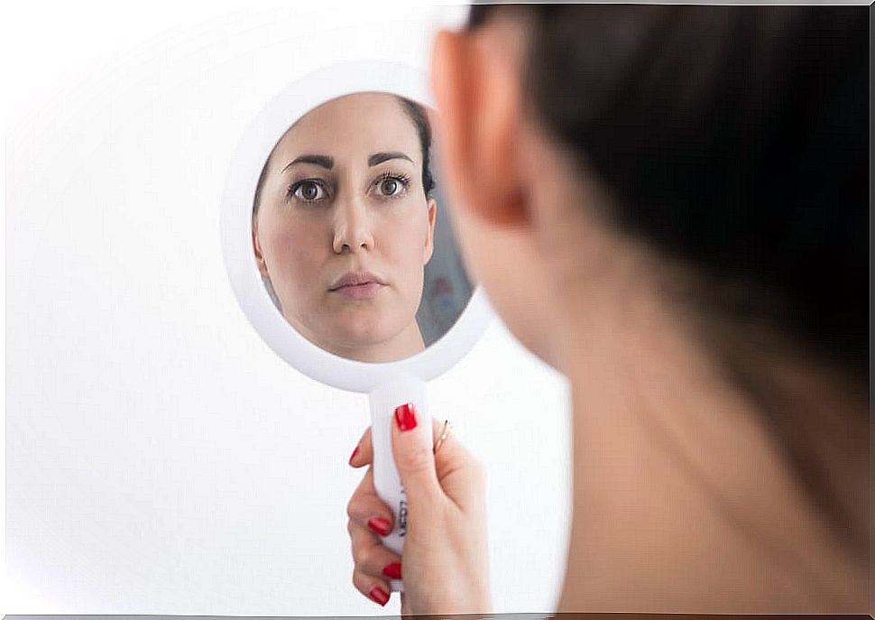 Woman looking at herself in the mirror