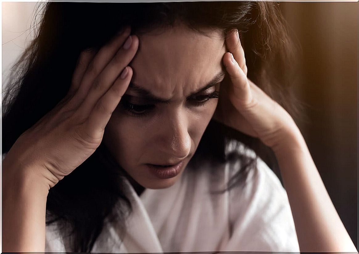 Woman with hands on head worried